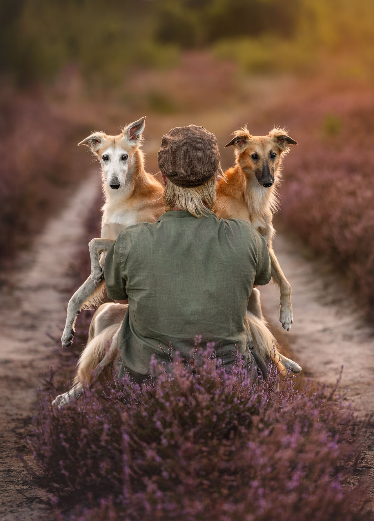 Person kneeling with two windsprites on the heath.